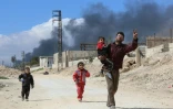 Un Syrien et des enfants sortent de la localité de Hammouriyé dans l'enclave rebelle de la Ghouta orientale, cible d'une offensive du régime, le 16 mars 2018