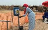 Une femme se lave les mains à l'entrée d'un unité d'isolement réservée aux malades du choléra, à Tawila, dans l'ouest du Soudan, le 12 août 2025