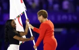 La maire démocrate de Los Angeles, Karen Bass (d) remettant le drapeau olympique à la gymnaste américaine Simone Biles (g) lors de la cérémonie de clôture des Jeux olympiques de Paris 2024 au Stade de France, le 11 août 2024