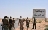 Des membres des forces gouvernementales à l'entrée de Deir Ezzor, le 3 septembre 2017, devant le panneau d'entrée dans la ville: "Bienvenue à Deir Ezzor" 