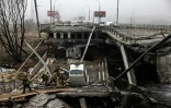Des soldats ukrainiens passent sur un pont détruit à l'entrée d'Irpin, près de Kiev, le 1er avril 2022