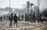Des déplacés palestiniens portent des produits alimentaires obtenus à un point de distribution du centre de la bande de Gaza, le 26 juillet 2025