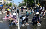 Des manifestants équipés de sacs en plastique remplis d'eau, pour les jeter sur les bombes de gaz lacrymogènes afin de les étouffer au maximum, le 1er mars 2021 à Rangoun