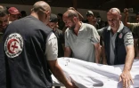 Des secouristes emportent le corps d'une victime d'une frappe sur l'église de la Sainte-Famille à Gaza, le 17 juillet 2025