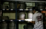Un employé de l'Institut taïwanais du cinéma et de l'audiovisuel (TFAI) sélectionne la bobine d'un vieux film taïwanais à restaurer, le 29 mai 2026 à Changhua, dans la province de Taïwan
