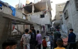 Des Palestiniens devant une maison détruite par un bombardement israélien à Khan Younès, dans le sud de la bande de Gaza, le 3 décembre 2023