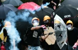 Un manifestant hongkongais renvoie vers la police une cartouche de gaz lacrymogène qui vient d'être tirée, à Yen Long le 27 juillet 2019