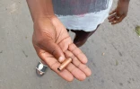 Un homme montre une douille de balle usagée dans une rue de Maputo, le 24 décembre 2024 au Mozambique