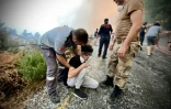 Un jeune homme est secouru par des pompiers et volontaires combattant un feu de forêt à Oren (Turquie), dans la région touristique de Mugla, le 6 août 2021