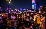 Des passagers portant des masques pour éviter de propager le coronavirus attendent d'embarquer dans un bateau pour regarder un spectacle, à Wuhan le 27 septembre 2020 