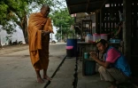Un moine bouddhiste bénit un migrant birman de l'ethnie Karen dans le village frontalier de Mae Sam Laep en Thaïlande le 31 mars 2021