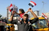 Un manifestant irakien porte une petite fille sur ses épaules sur la place Tahrir dans la capitale irakienne Bagdad, le 1er novembre 2019