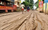 Un habitant marche dans une rue boueuse de Cochin, au Kerala indien, le 20 août 2018