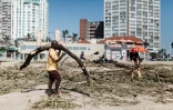 Des résidents nettoient la plage de North Beach à Durban, le 15 avril 2022