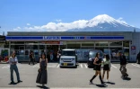 Des touristes dans une rue de la ville de Fujikawaguchiko avant l'installation d'un vaste filet pour cacher la vue du Mont Fuji, le 3 mai 2024 au Japon
