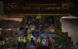 Des manifestants enveloppés dans des couvertures de survie, aidés par des équipes de secours, quittent le campus de l'université polytechnique de Hong Kong, le 19 novembre 2019
