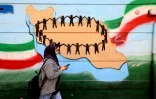 Une femme passe devant une fresque murale à Téhéran, le 25 février 2026
