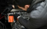 Un mécanicien travaille la transformation du moteur d'une Volkswagen Karmann Ghia en moteur électrique dans l'atelier de l'entreprise London Electric Cars, le 6 mai 2022 à Londres