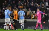 Sergio Aguero de Manchester City, en bleu, et Ruben Neves des Wolverhampton Wanderers, en orange, discutent alors que le gardien de City, Ederson, a pris un carton rouge lors du match entre les deux équipes au stade Molineux à Wolverhampton le 27 décembre 2019.
