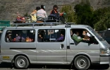 Des personnes voyagent sur le toit d'un minivan chargé après la réouverture d'une route, auparavant bloquée par des  manifestations réclamant la démission du président bolivien Rodrigo Paz à Carreras, dans le département de La Paz, en Bolivie, le 5 juin 2026