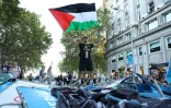 Un manifestant propalestinien brandit un drapeau palestinien alors que les manifestants ont envahi les rues pendant la 21e et dernière étape du Tour d'Espagne cycliste, le 14 septembre 2025 à Madrid