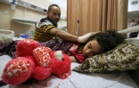 Un Palestinien veille sur sa fille, blessée par une frappe israélienne, dans un hôpital de Gaza, le 19 mai 2021
