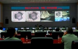 Sur cette image d'archive du 24 juin 2012, des techniciens chinois du Centre spatial de Jiuquan suivent l'arrimage du vaisseau Shenzhou-9 Ă la station spatiale Tiangong-1.