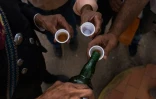 Des vénézuéliens boivent une boisson locale à base d'agave le cocuy lors d'une fête religieuse à Bobaré, le 12 décembre 2019