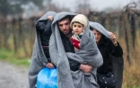 Des migrants marchent sous la pluie après avoir traversé la frontière entre la Grèce et la Macédoine, à Gevgelija, le 27 novembre 2015