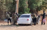 Des membres des forces de sécurité soudanaises fouillent un véhicule, le 20 mai 2023 à Khartoum