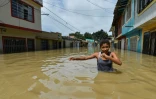 Une fille marche à travers une rue inondée à Cali, en Colombie, le 13 mai 2017