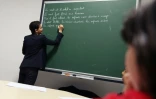 La ministre de l'Education nationale Najat Vallaud-Belkacem écrit sur le tableau lors de sa visite d'une école au Havre le 22 février 2016