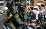 Des policiers vénézuéliens se fraient un chemin lors d'une manifestation en faveur Juan Guaido, le 10 avril 2019 à Caracas