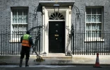 Des employés nettoient la rue devant l'entrée du 10 Downing Street, résidence officielle du Premier ministre britannique, le 9 mai 2026, à Londres