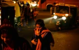 Un passant tente  de se protéger de la pollution le 18 décembre 2015 derrière le terminal de bus dans le quartier d'Anand Vihar à New Delhi