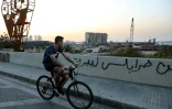Un jeune homme passe à vélo devant le port de Beyrouth, le 6 avril 2021