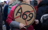 Une manifestante tient une pancarte avec "A69" barré lors d'une manifestation contre l'autoroute A69, à Toulouse (Haute-Garonne), le 15 décembre 2024