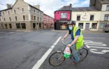 Un homme à vélo portant un masque devant le "Tery's bar", fermé à cause de la pandémie de coronavirus, dans le village de Dunmore, dans l'ouest de l'Irlande, le 3 septembre 2020 