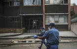 Des policiers tirent des balles en caoutchouc pour disperser plusieurs centaines de personnes faisant la queue devant un supermarché, le 28 mars 2020 à Johannesburg