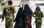 Des proches de jihadistes escortées par des gardes armés dans le camp de Al-Hol, dans le nord-est de la Syrie, le 23 juillet 2019 