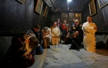 Des pèlerins chrétiens prient sur le lieu de naissance présumé de Jésus, dans la basilique de la Nativité à Bethléem, le 24 décembre 2018 en Cisjordanie