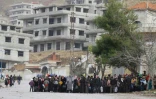 Des habitants de la ville assiégée de Madaya attendent un convoi d'aide humanitaire, le 14 janvier 2016 en Syrie