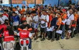 Des conducteurs de tricycles font la queue pour la distribution d'une subvention sur le carburant à Manille, le 17 mars 2026 aux Philippines