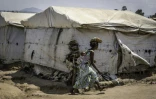 Une femme déplacée, son enfant sur le dos, traverse le camp de Kigonze à Bunia, dans l'est de la République démocratique du Congo, le 28 mai 2026 alors qu'une épidémie d'Ebola touche le pays