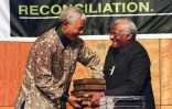 Le président sud-africain Nelson Mandela (g) reçoit cinq volumes de la Commission vérité et réconciliation des mains de son président Desmond Tutu, à Pretoria, le 29 octobree 1998