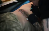 Un militaire ukrainien se fait tatouer le nom "Azovstal" au festival "Art Weapon" de Kiev, le 14 mai 2022