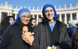 Des religieuses avec une figurine représentant l'enfant Jésus lors d'une bénédiction place Saint Pierre au Vatican le 20 décembre 2015