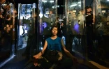 Une femme médite devant les forces de l'ordre, le 12 juin 2019 à Hong Kong