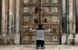 Un Chrétien prie devant les portes fermées du Saint-Sépulcre, à Jérusalem, le 9 avril 2020