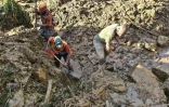 Des habitants creusent dans les décombres après un gigantesque glissement de terrain dans le village de Yambali, en Papouasie-Nouvelle-Guinée, le 27 mai 2024